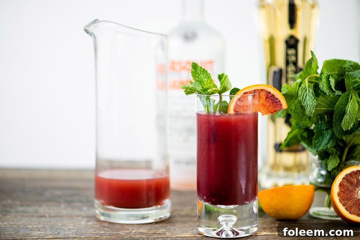 Blood orange and pomegranate screwdriver cocktail on table.