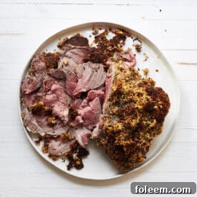 Herbed Boneless Leg of Lamb with Mustard Crust sliced on platter.