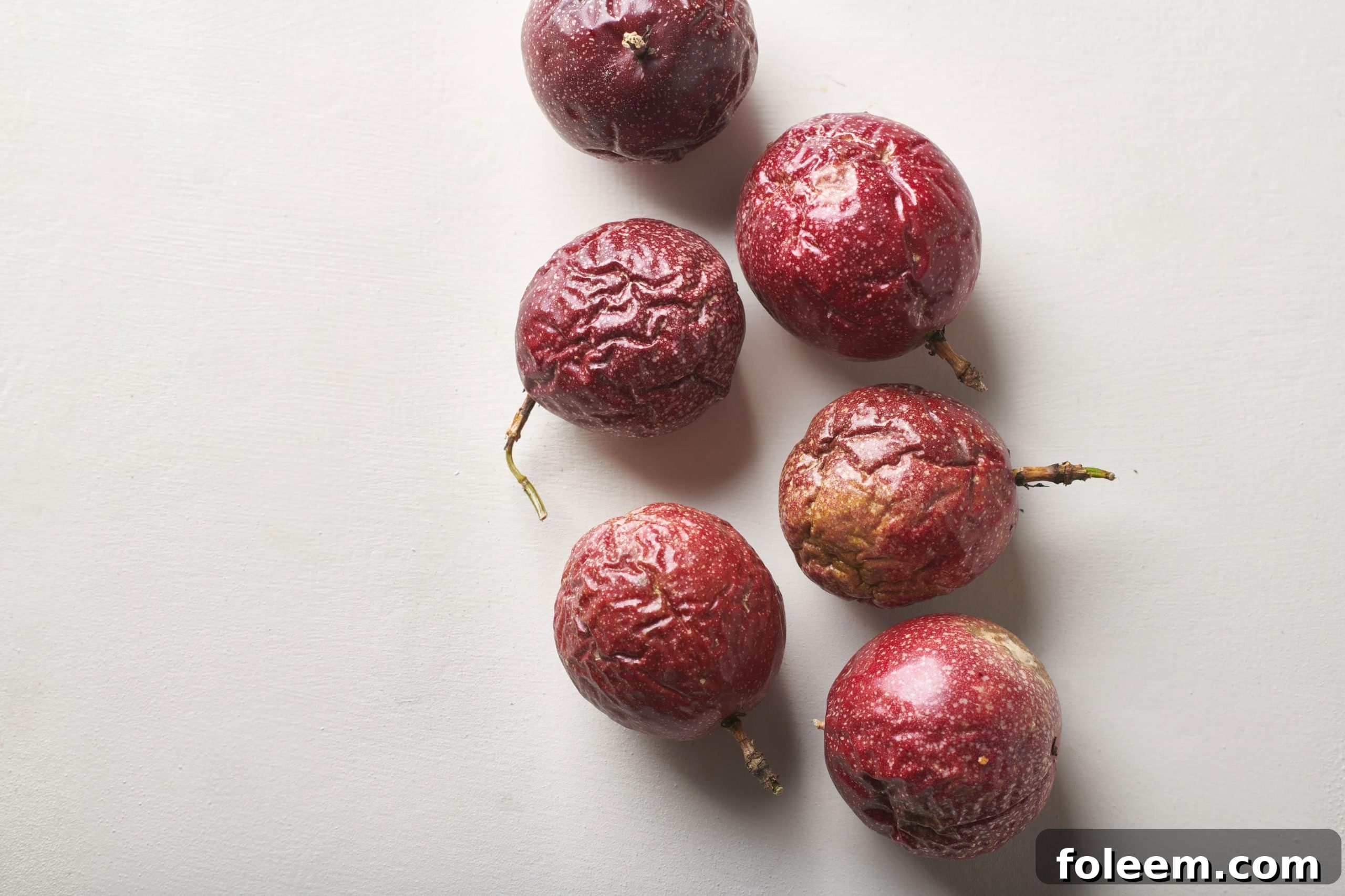 Ripe passion fruit on a white counter.