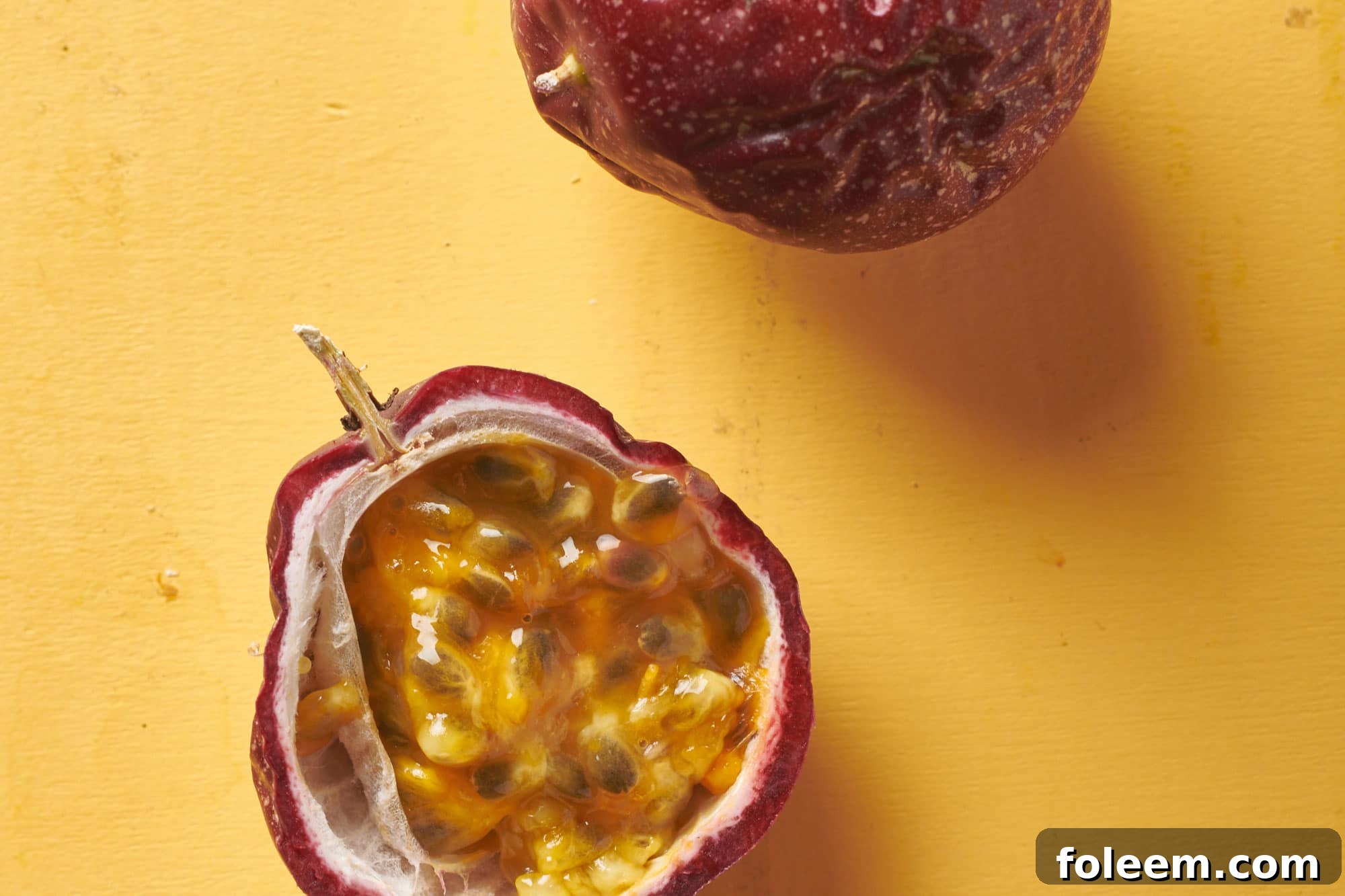 Half of a passion fruit with the seeds and juice inside.