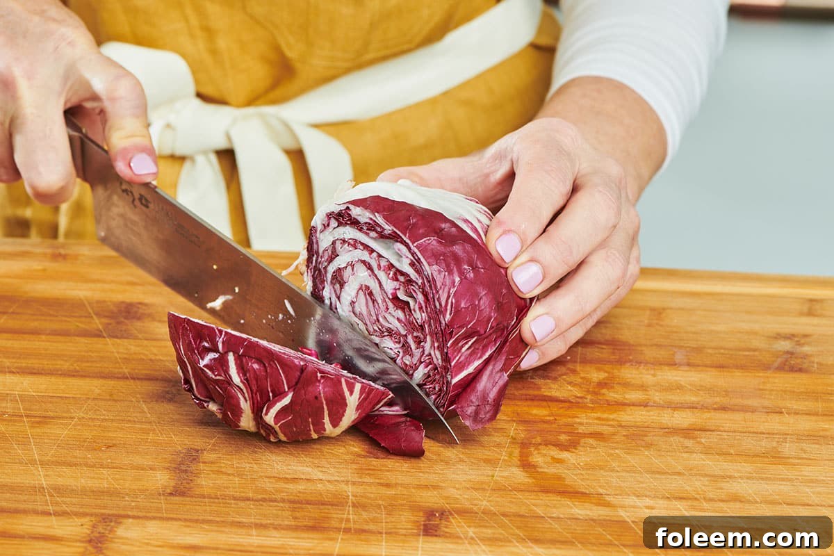 Cutting radicchio on board with knife.