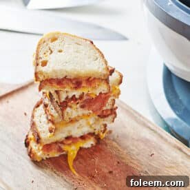 Stack of grilled cheese sandwiches near air fryer.