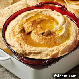 Homemade hummus in bowl with pita chips.