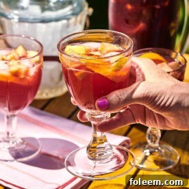 Woman holding a long-stemmed glass of Red Sangria.