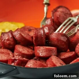 Air fried kielbasa in red bowl with mustard.