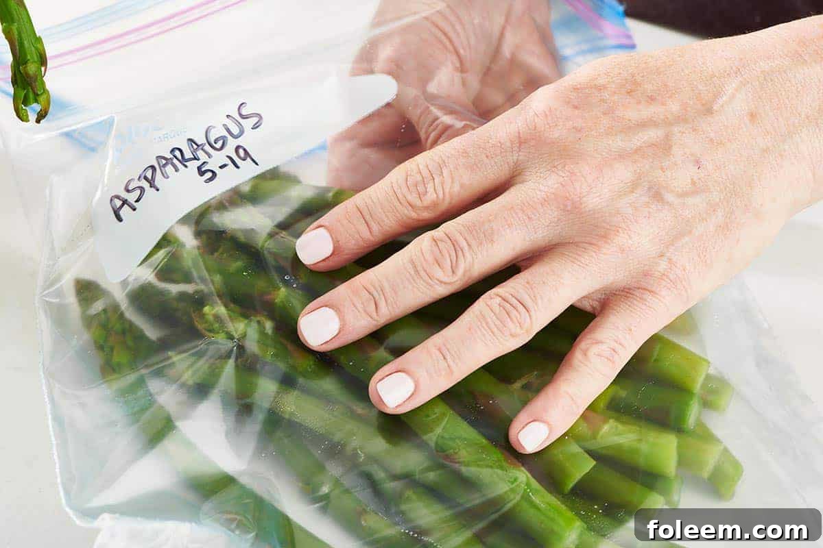 Placing asparagus in freezer bag.