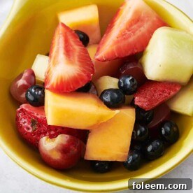 Mixed fruit salad in small yellow bowl.