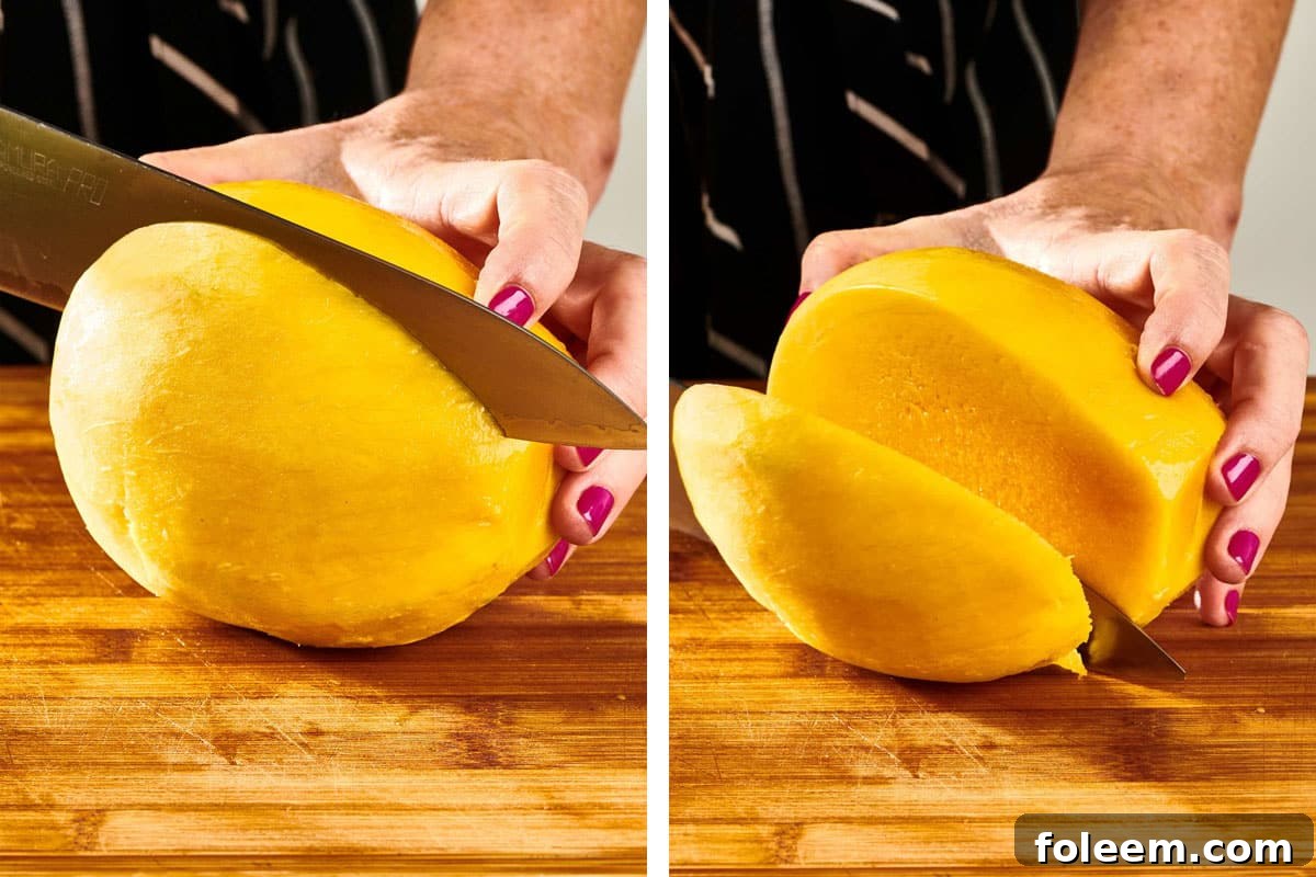 Woman cutting peeled  mango with knife on cutting board.