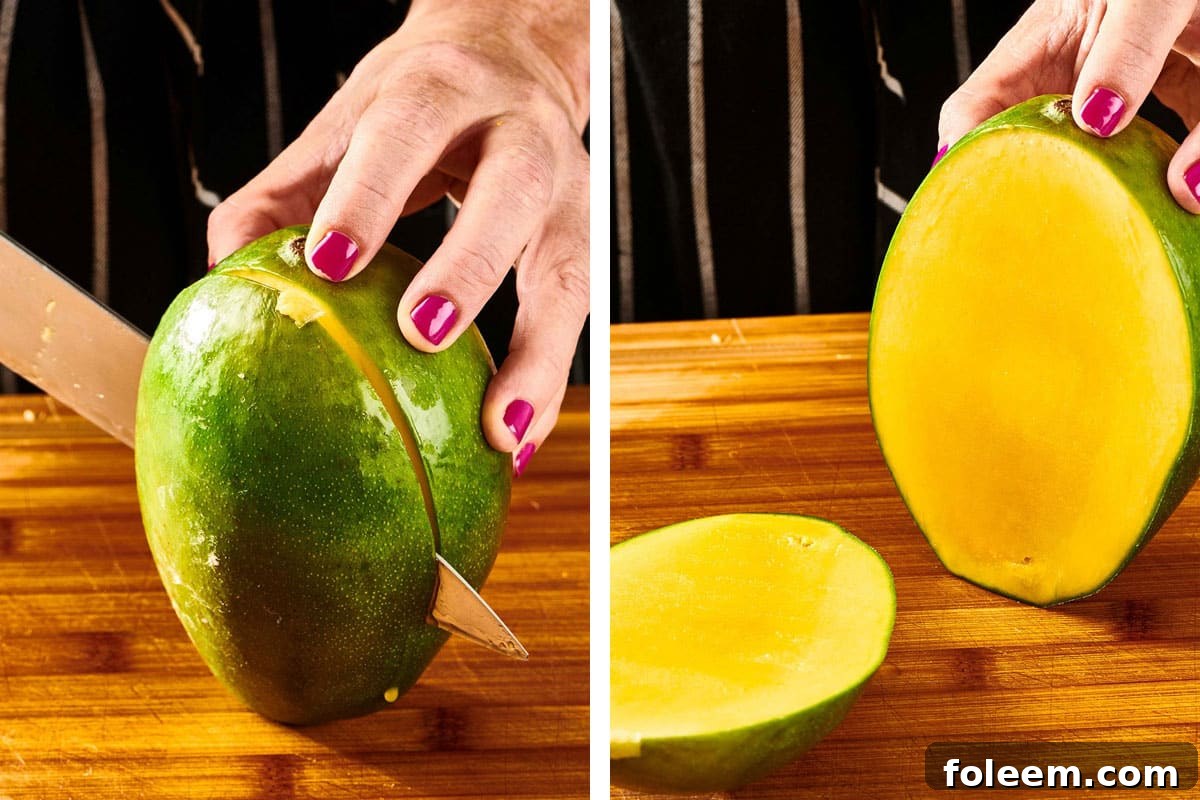 Woman cutting lage piece off unpeeled mango.