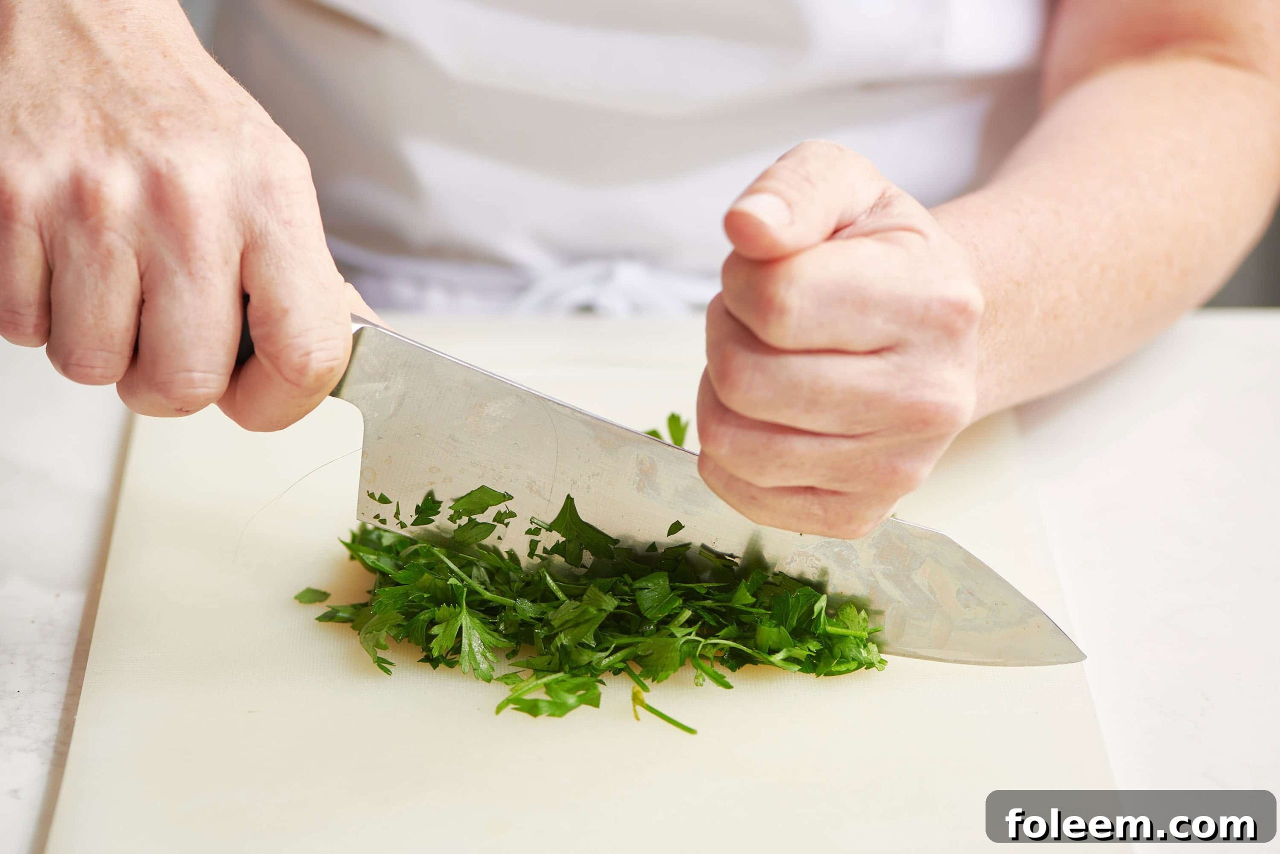 Chopping parsley with chef knife.