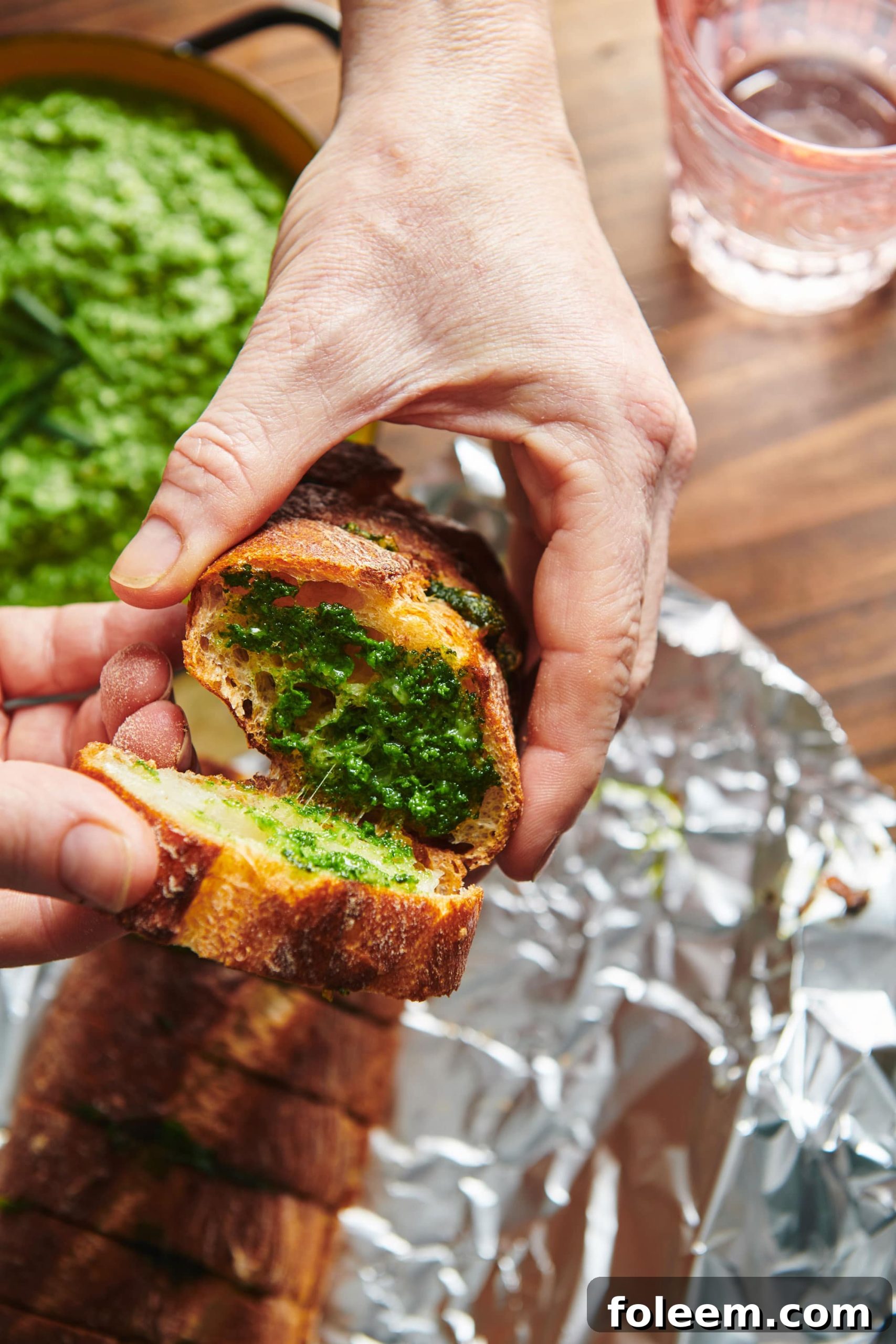 Pulling apart slices of Spinach Parsley Pesto Garlic Bread.