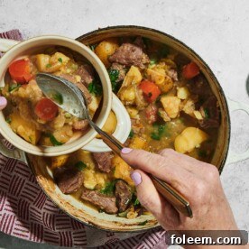 Woman scooping Irish Lamb Stew from cooking pot into bowl.