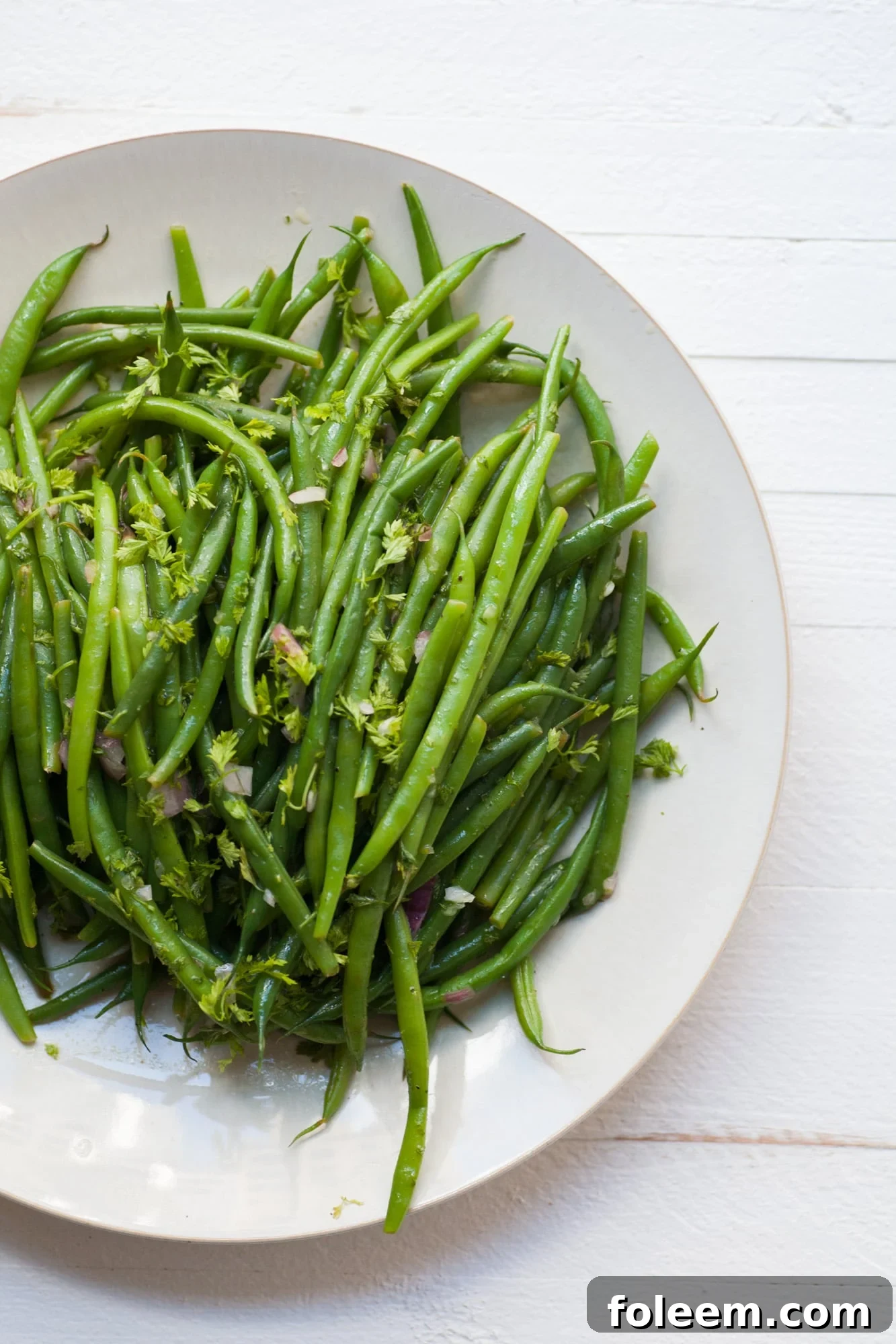 Haricot Verts with Chervil Vinaigrette on white plate.