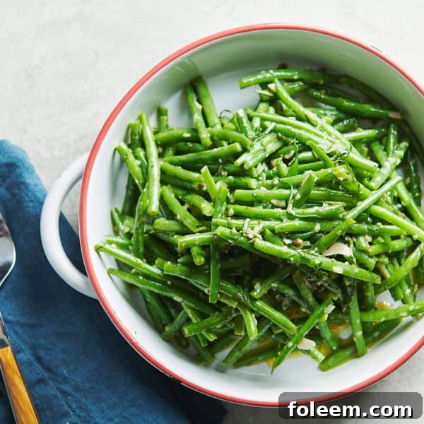 Green Bean Nicoise Salad in white bowl on table.
