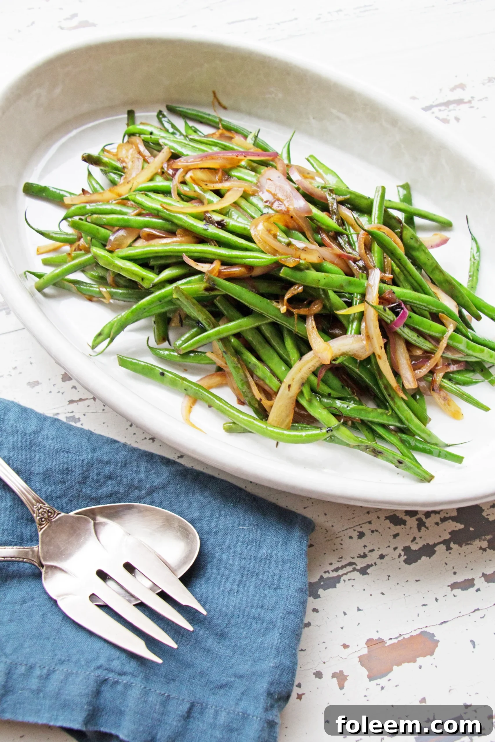 Sautéed Haricot Verts with Red Onions and Shallots in white oblong serving dish.