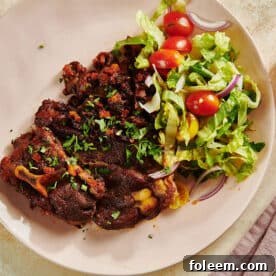 Salad and Braised Lamb Shoulder Chops on a white plate.