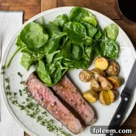 Plate with ribeye in thyme-garlic butter, salad, and roasted potatoes.