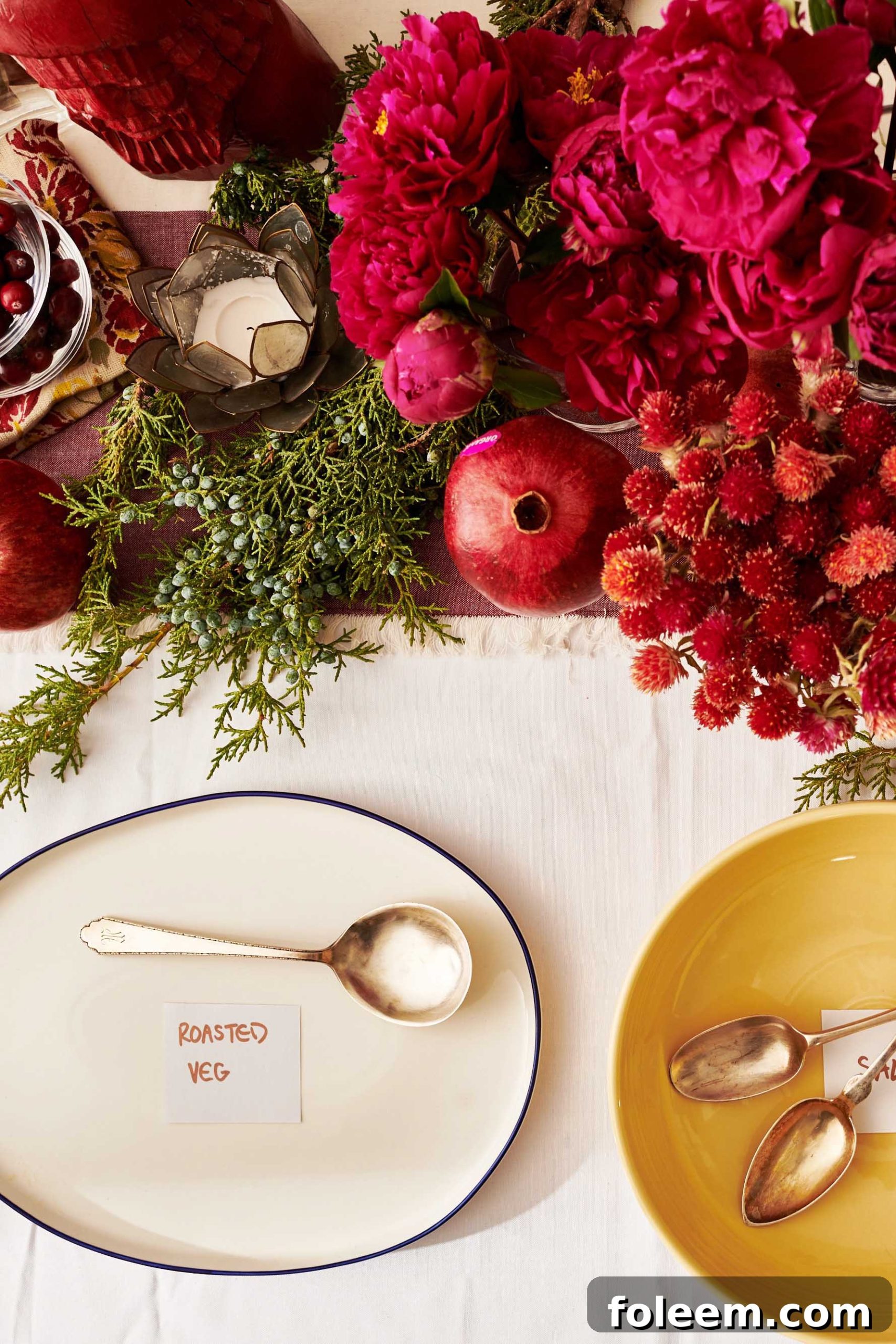Table with a decorated centerpiece and serving plates with food labels.