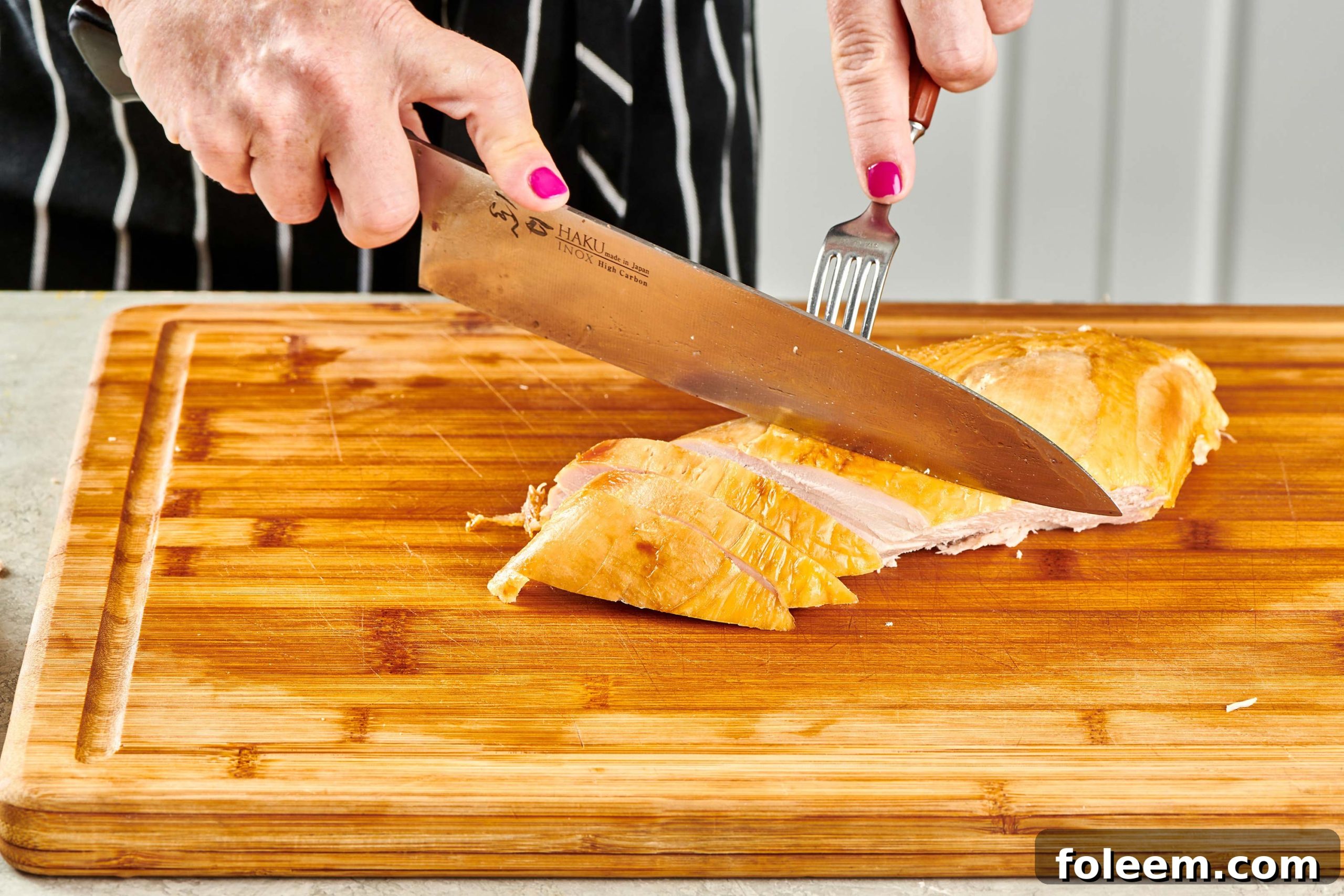 Woman slicing turkey breast.