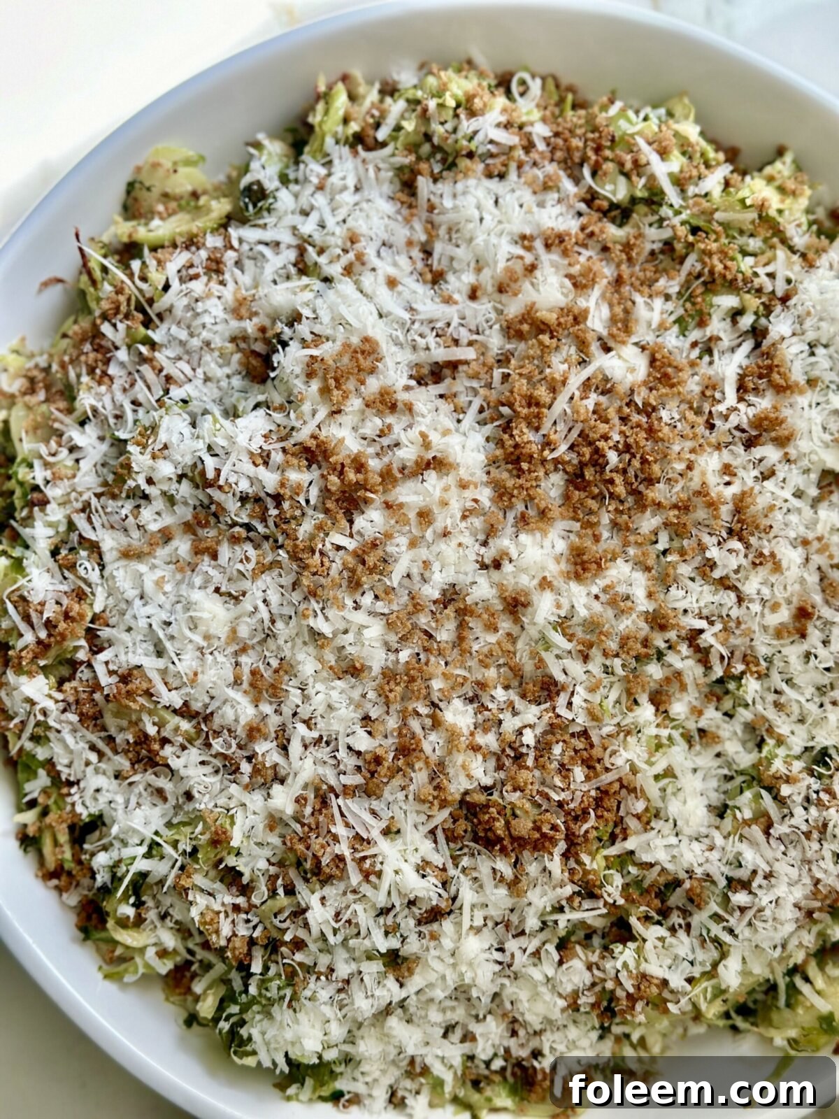 an overhead shot of brussels sprout caesar salad in a white bowl 