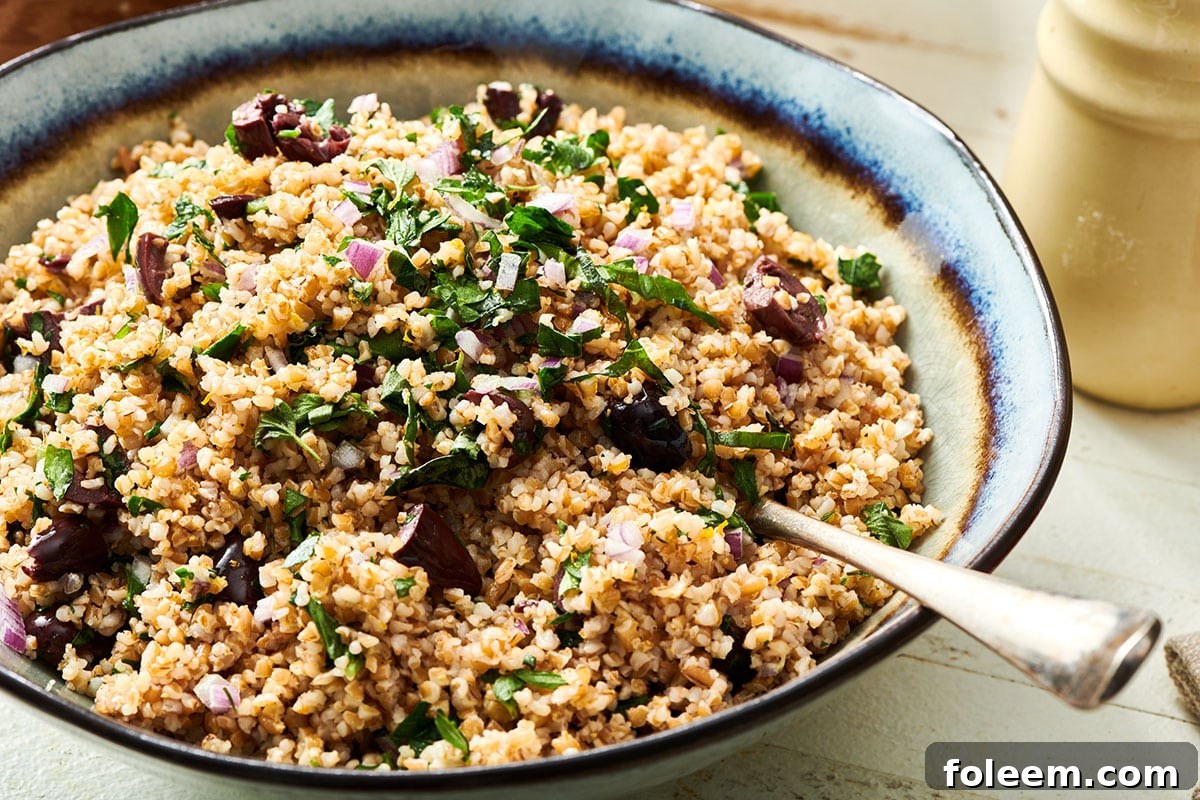 Bulgur wheat salad in bowl with serving spoon.
