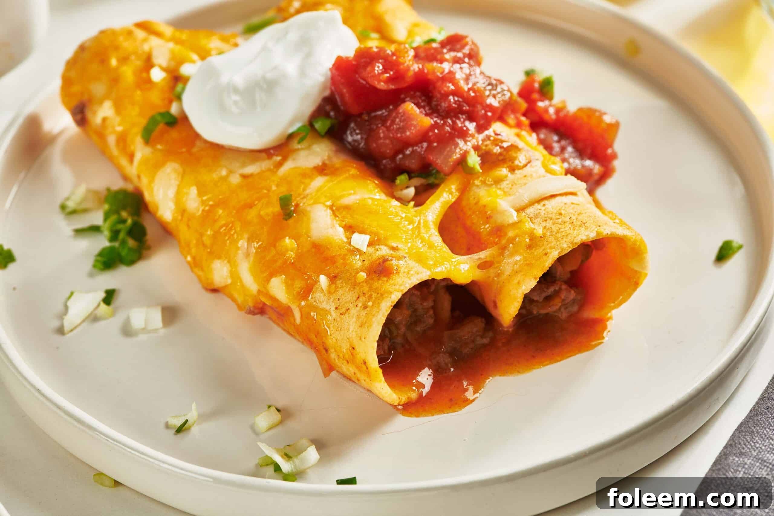 Ground Beef Enchiladas on white plate.