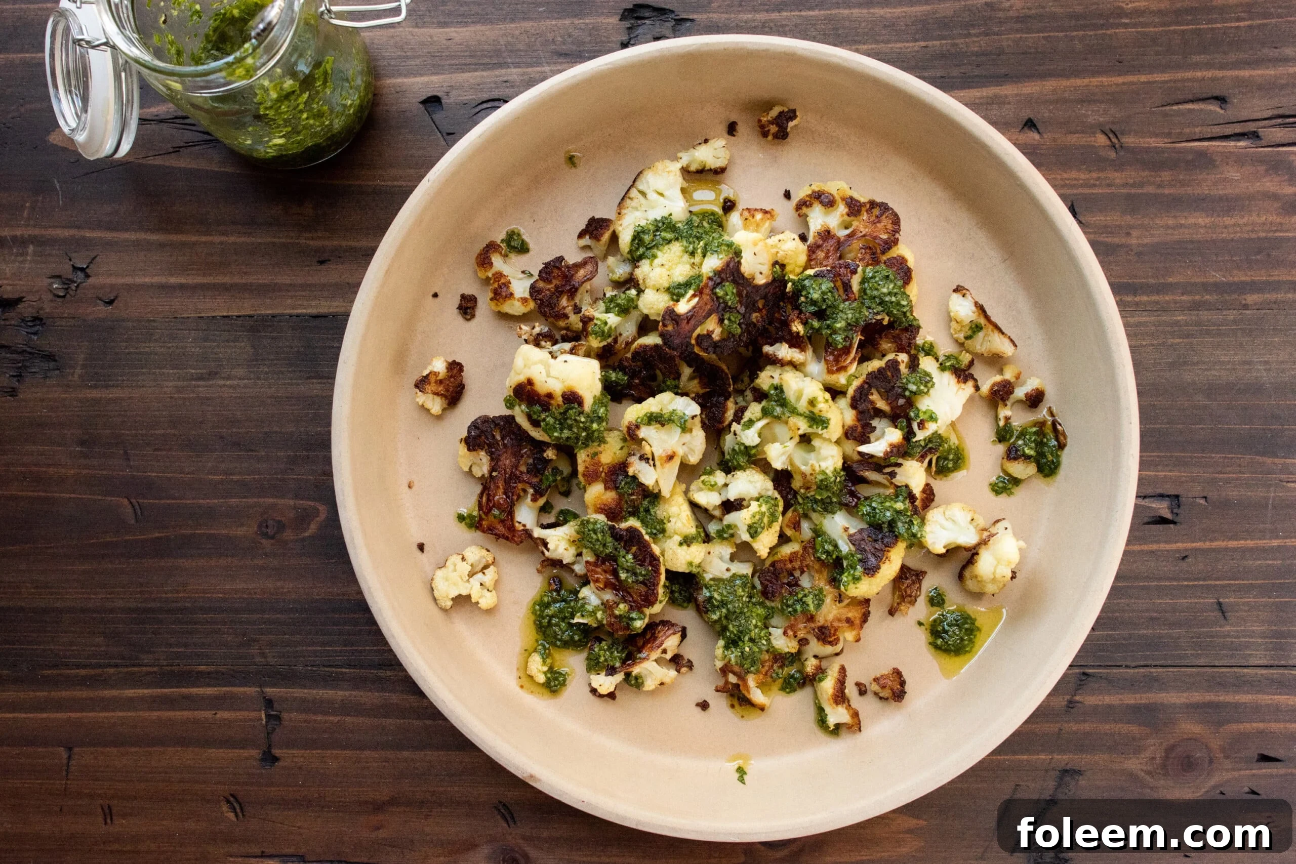 Roasted Cauliflower with Chimichurri Sauce on light brown plate.