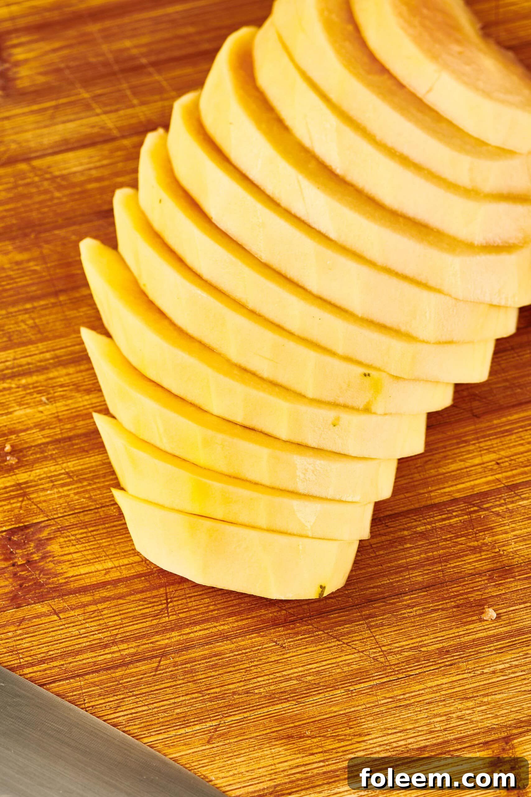 Sliced, peeled Papaya on a wooden cutting board.