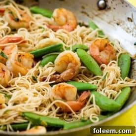 Shrimp, Sugar Snap Pea and Scallion Stir Fry with Miso Sauce in wok on table.