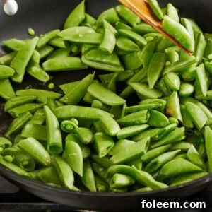 Sauteing sugar snap peas in pan.