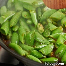 Seasoned Soy Glazed Sugar Snap Peas cooking in pan.