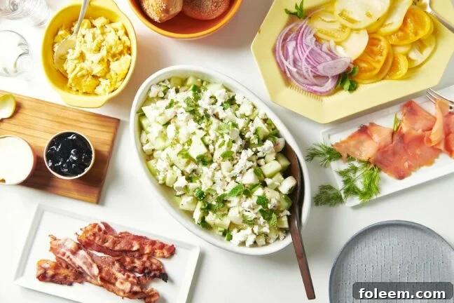 Table set with plates and bowls on ingredients including eggs, bacon, and red onion.