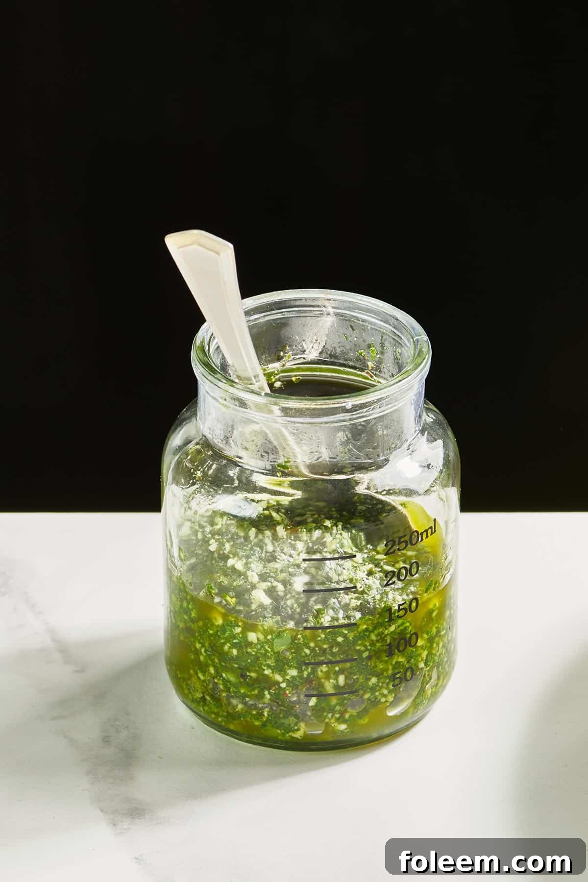 Jar filled with nut-free basil pesto.