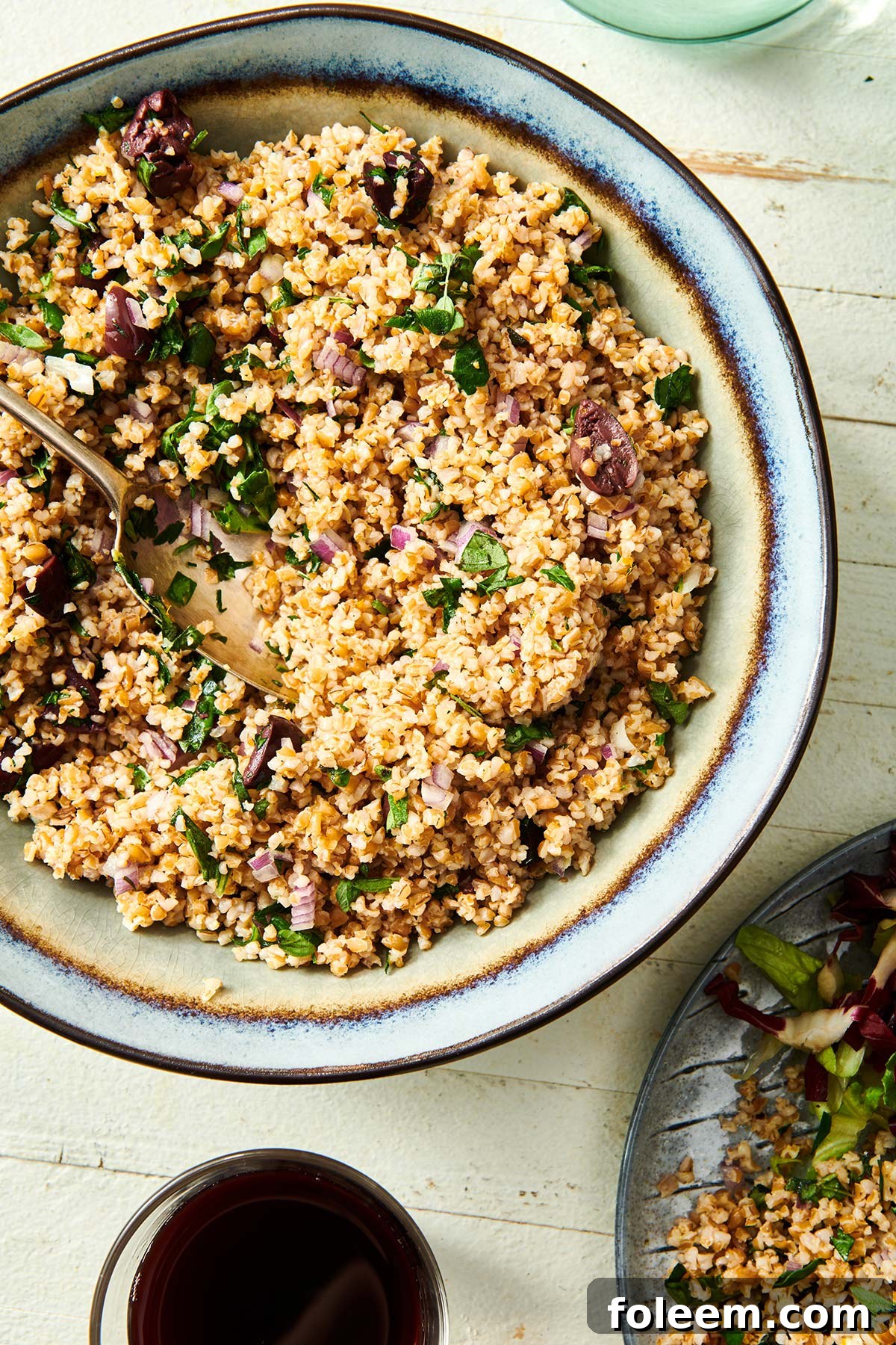 Table setting with bowl full of bulgur wheat salad.
