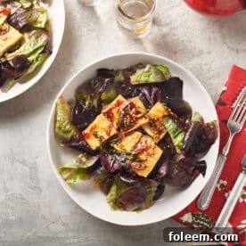 Korean tofu salad on plates with red napkins and silverware.