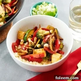 White bowl of Stir Fried Crispy Tofu and Vegetables and rice.