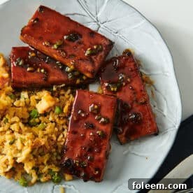 Air-fried tofu with sticky Chinese barbecue sauce on white plate with sides.