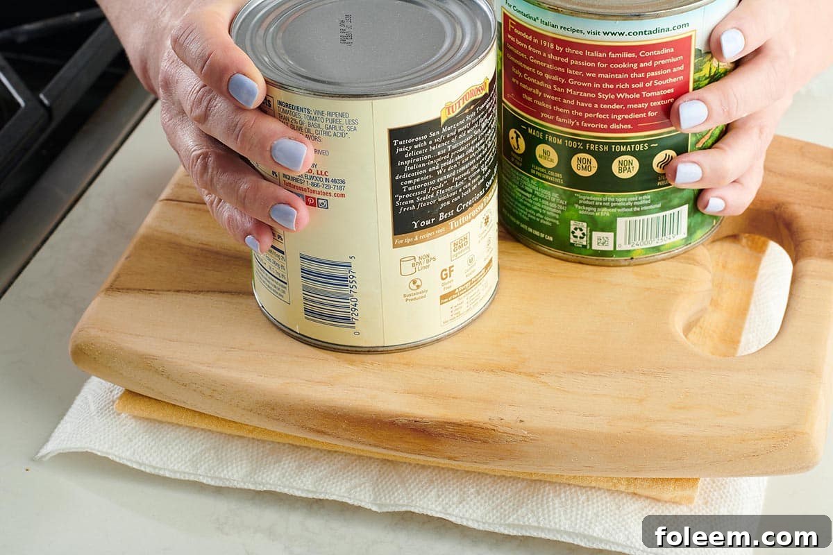 Woman placing large cans onto a cutting board pressing tofu.