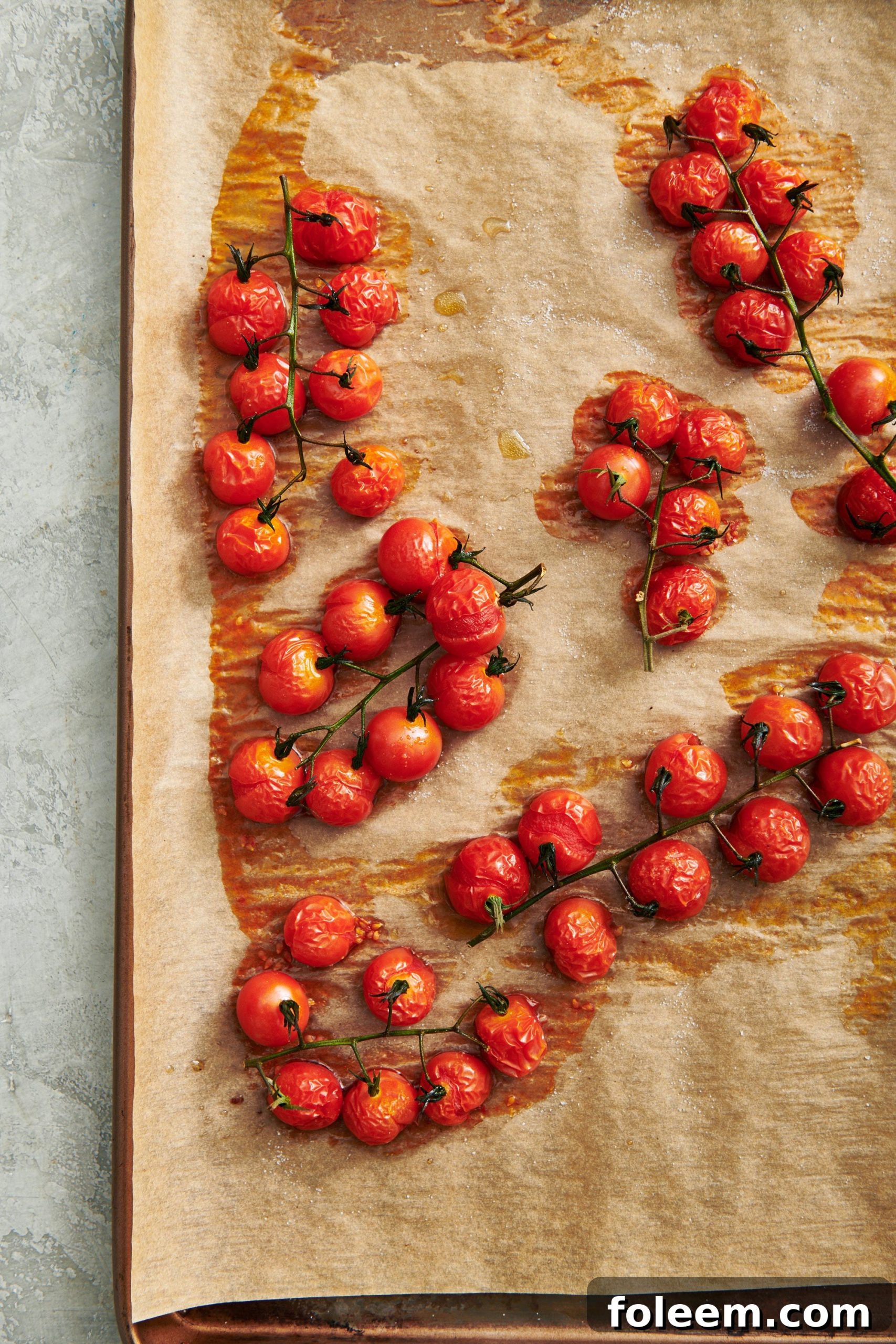 Roasted Cherry Tomatoes Recipe for Flavorful Side Dish 6 Roasted cherry tomatoes on baking tray covered with parchment paper.