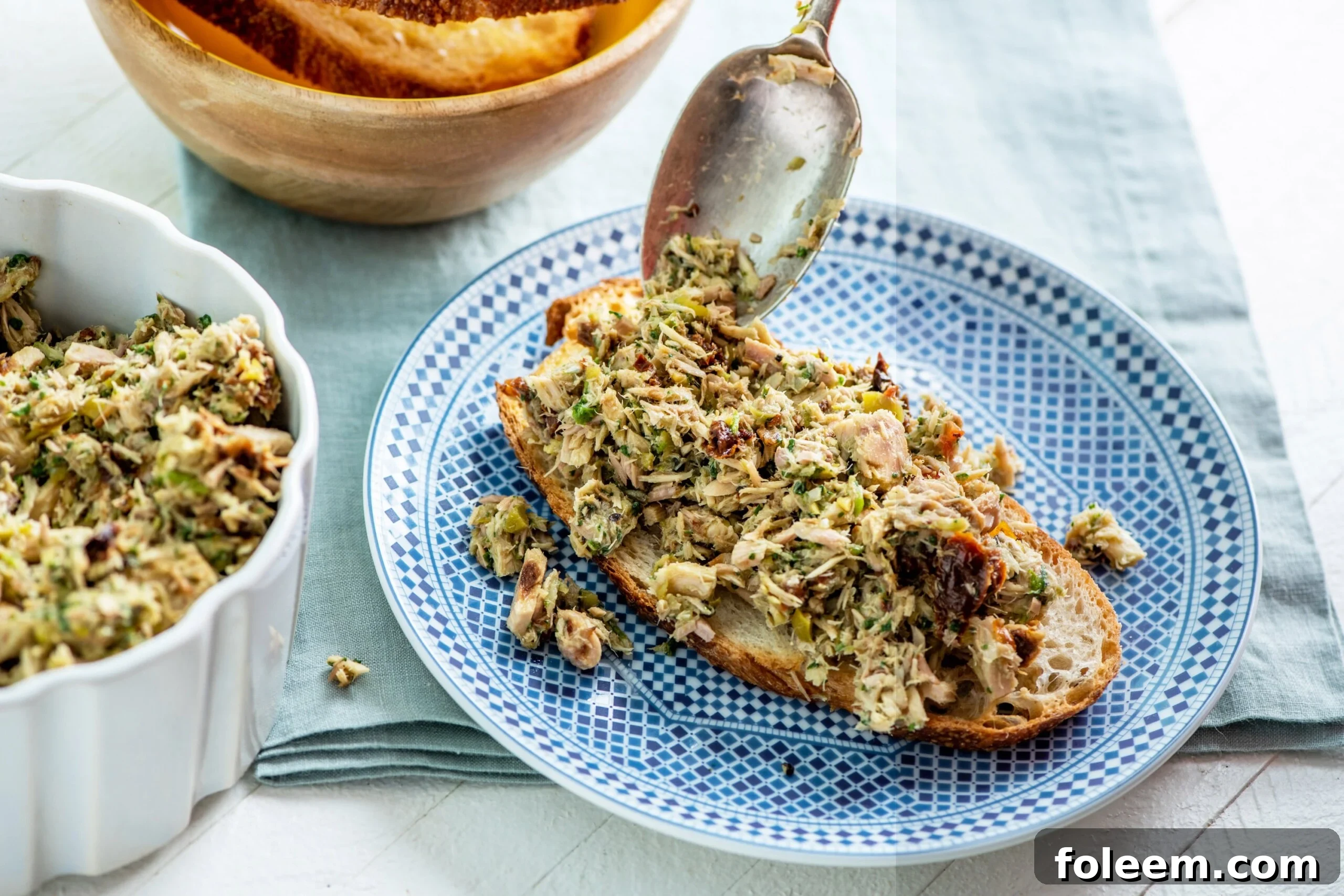 Building Italian Tuna Salad on blue plate.