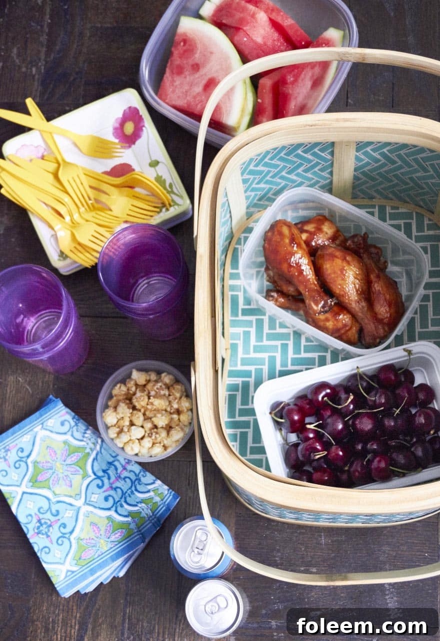 Chicken, cherries, and popcorn in plastic containers with a basket.