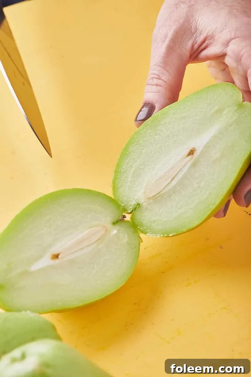 Woman cutting a fresh chayote in half