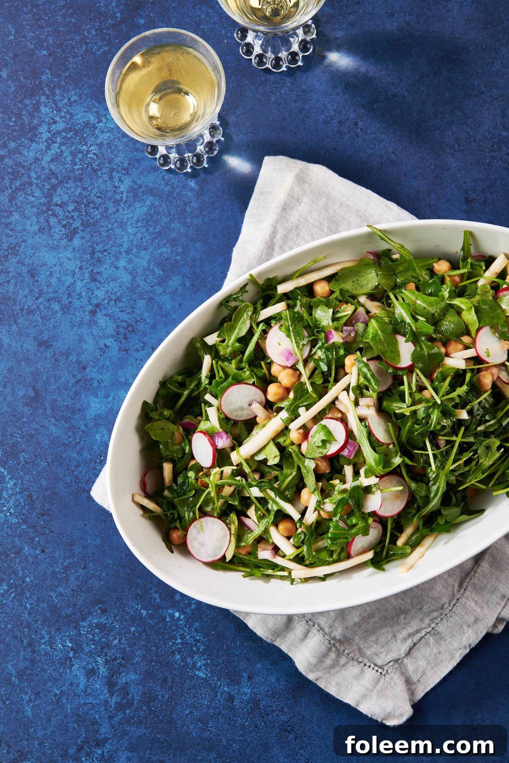 Bowl of Winter Salad on a blue table.