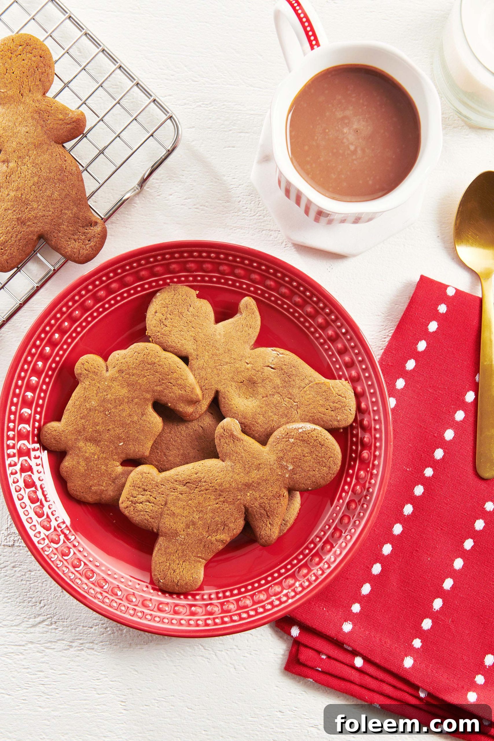 Four Gingerbread Cookies set on a red plate.