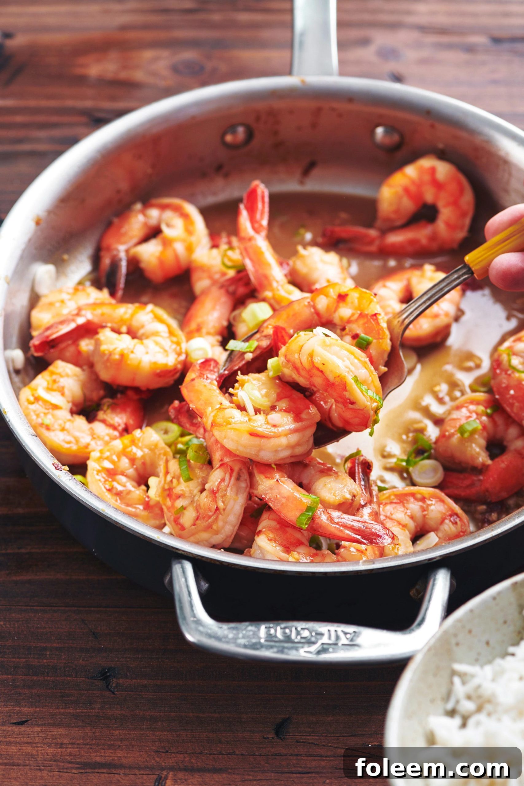 Honey Garlic Shrimp in saucepan on wood table.