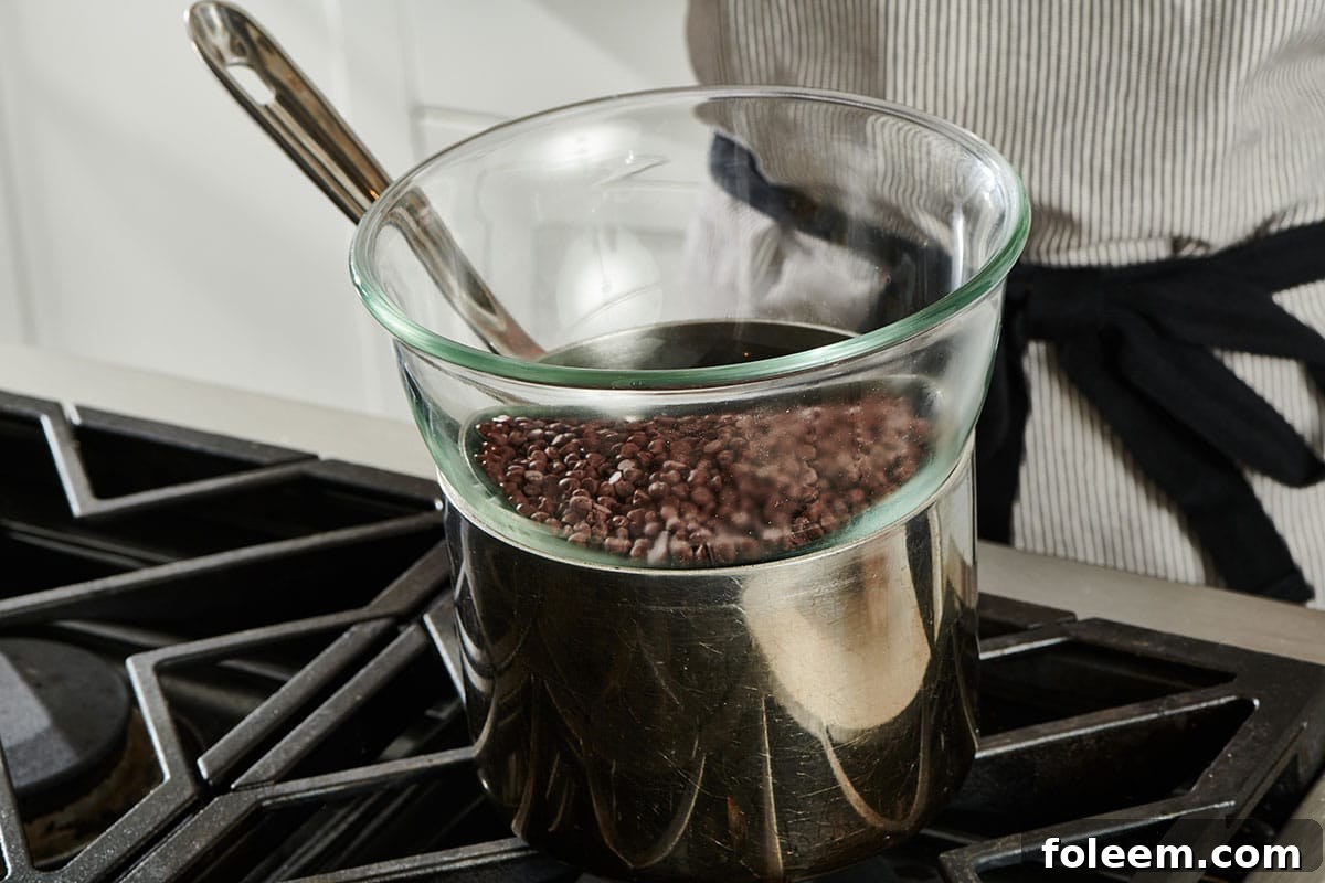 Homemade double boiler with chocolate on stove.