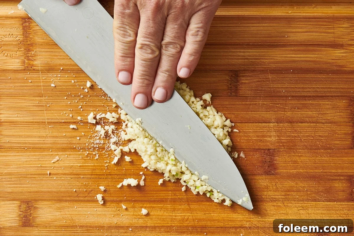 Mincing garlic with chef knife.