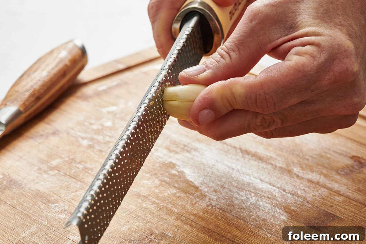 Grating fresh garlic clove.