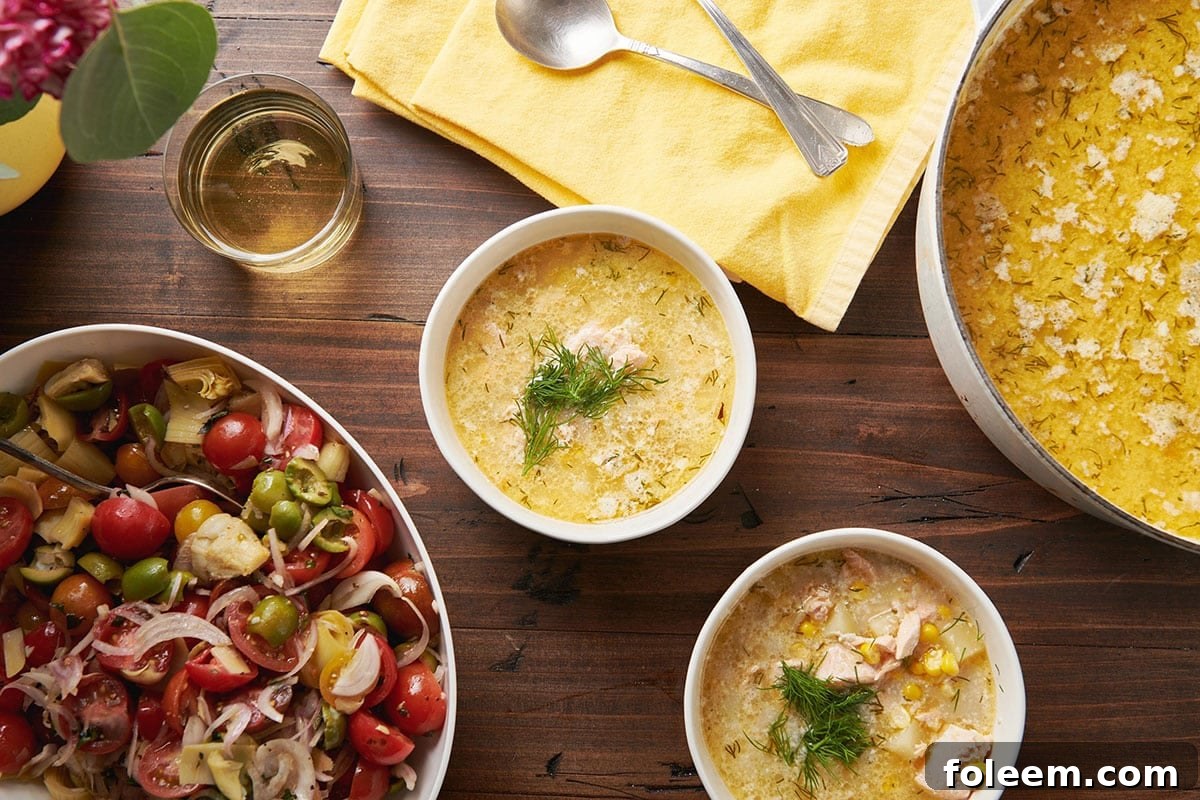 Bowls of salmon corn chowder with fresh dill garnish on table.