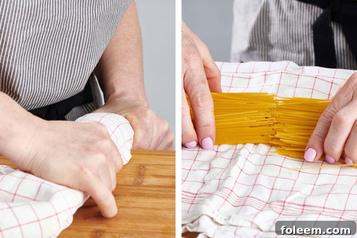 Woman breaking spaghetti in half on a cutting board edge.